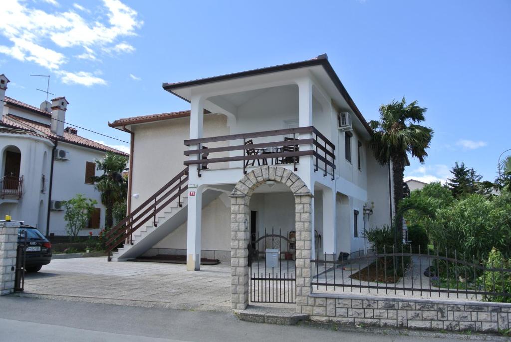 une maison blanche avec un portail et un escalier dans l'établissement Apartmaji NIKA, à Izola
