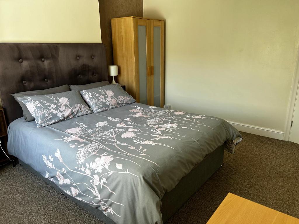 a bedroom with a bed with a gray comforter at Ortari@70 in Bishopston