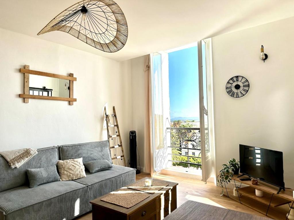 un salon avec un canapé et une grande fenêtre dans l'établissement Hyères Centre, à Hyères