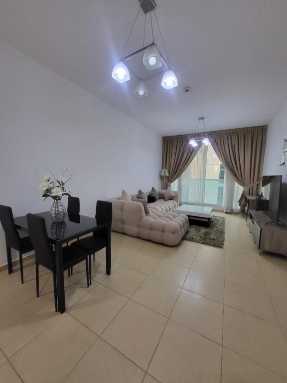 a living room with a couch and a table and chairs at Noha Home in Dubai