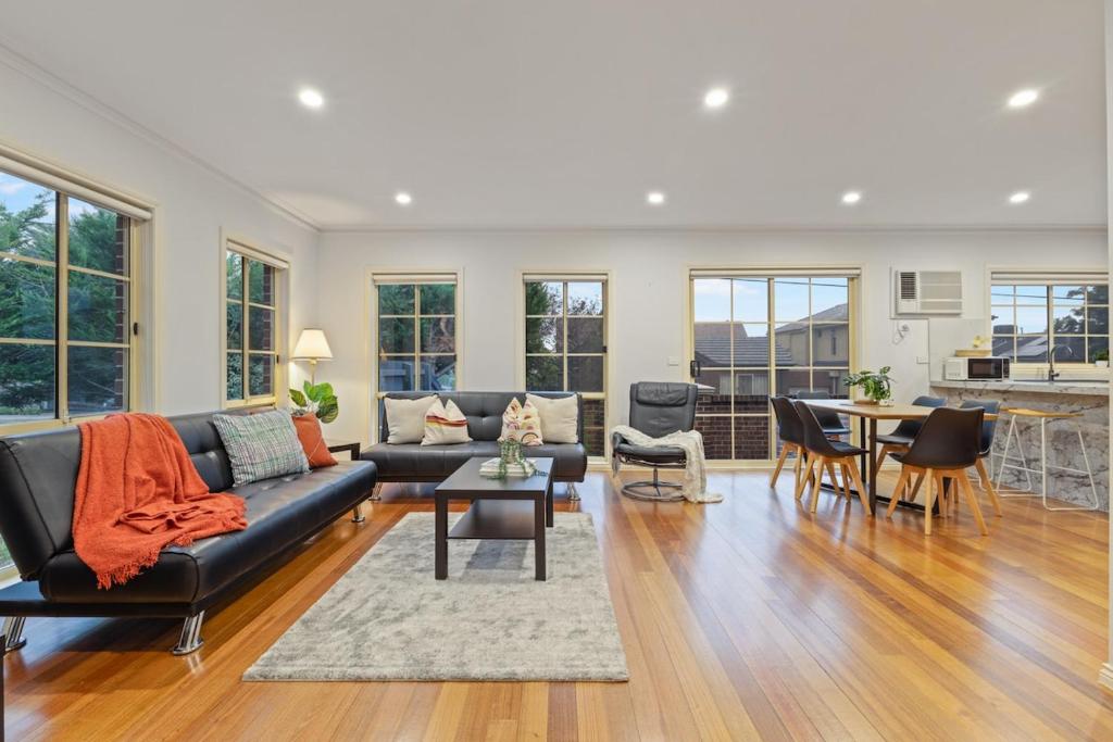 a living room with a couch and a table at Elegant 3-Bedroom Retreat in Prime Glen Waverley in Glen Waverley