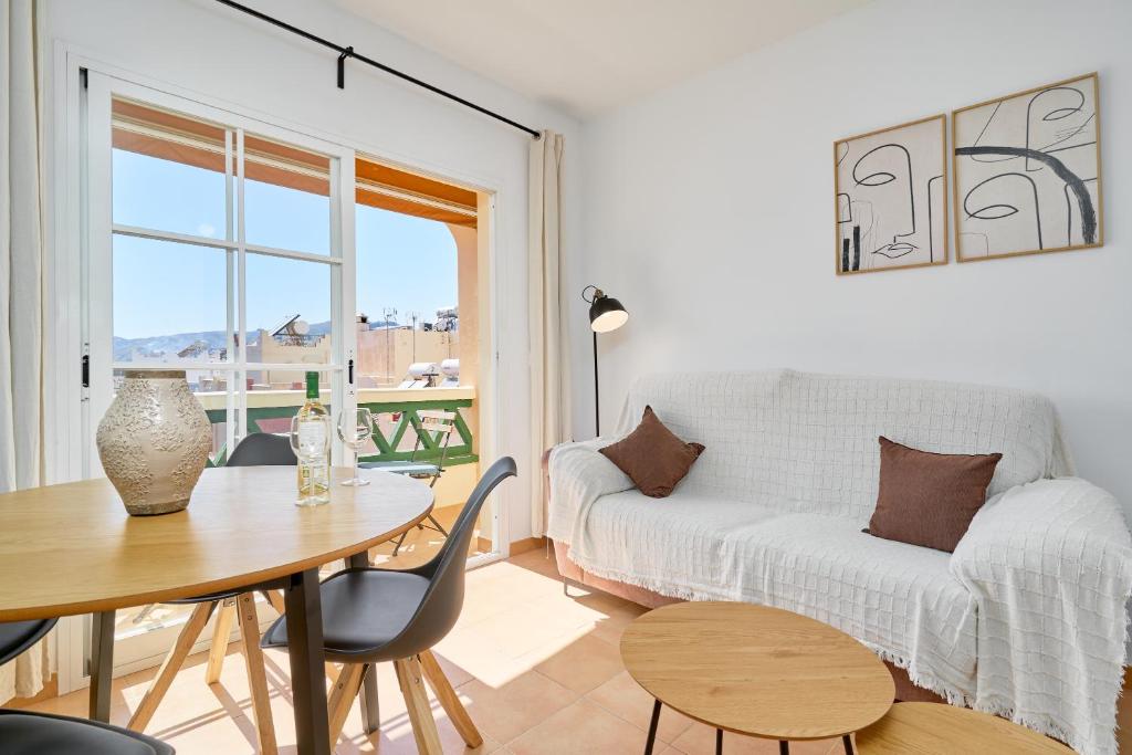 una sala de estar con una mesa y un sofá en Apartamento Mani, en Nerja