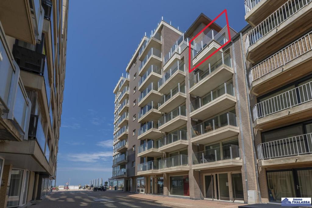 a tall building with a red ribbon on the side of it at Le Roulis 0501 - 2 bedrooms 6p - near the sea and promenade in De Panne