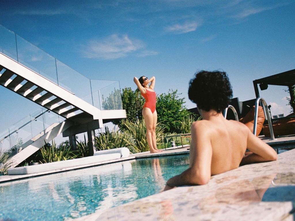 un uomo e una donna in piedi in una piscina di 21 House of Stories Navigli a Milano