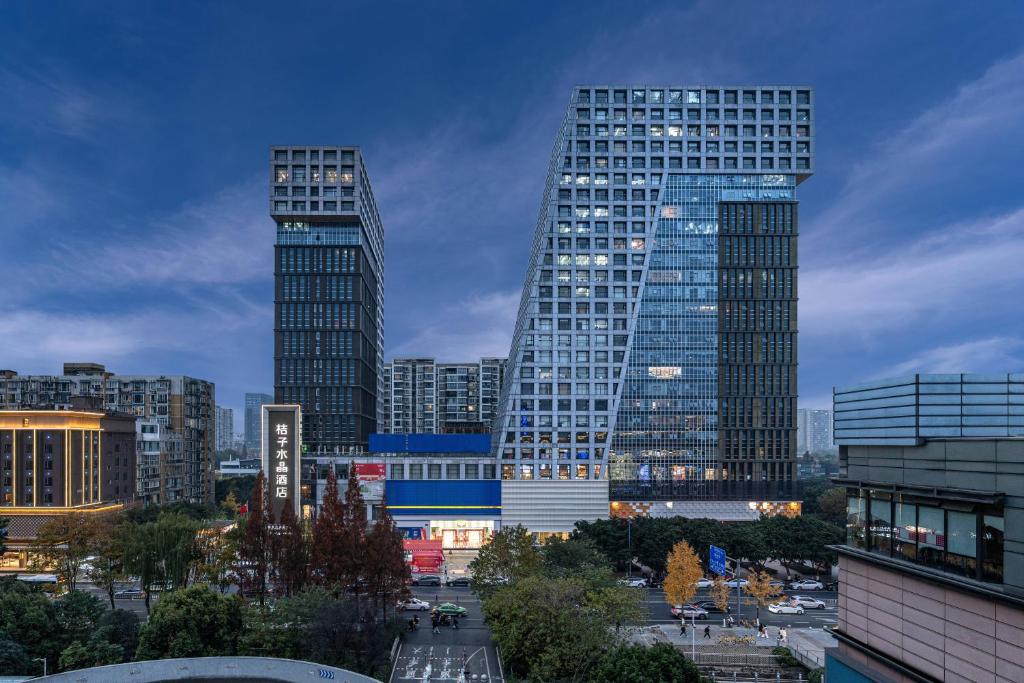 two tall skyscrapers in a city at dusk at Orange Crystal Chengdu Financial City South Railway Station Hotel in Chengdu
