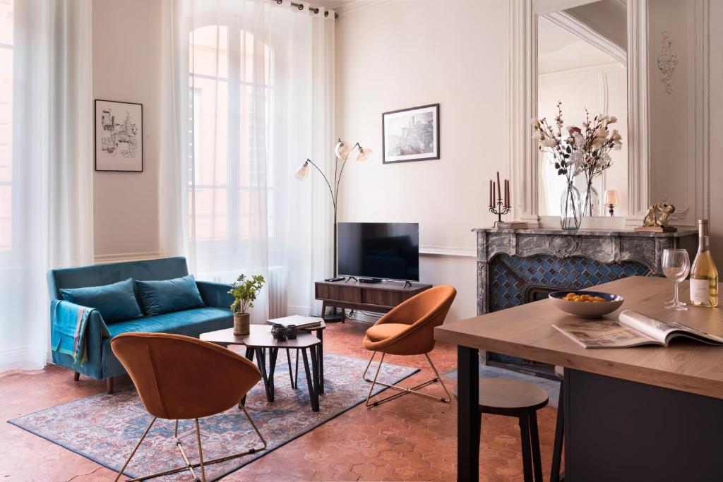 un salon avec un canapé bleu et une table dans l'établissement Built in Dream, à Grasse