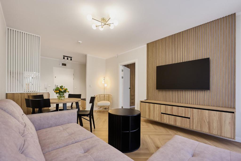 斯维诺乌伊希切Apartamenty Nautilus 103的客厅配有沙发和墙上的电视