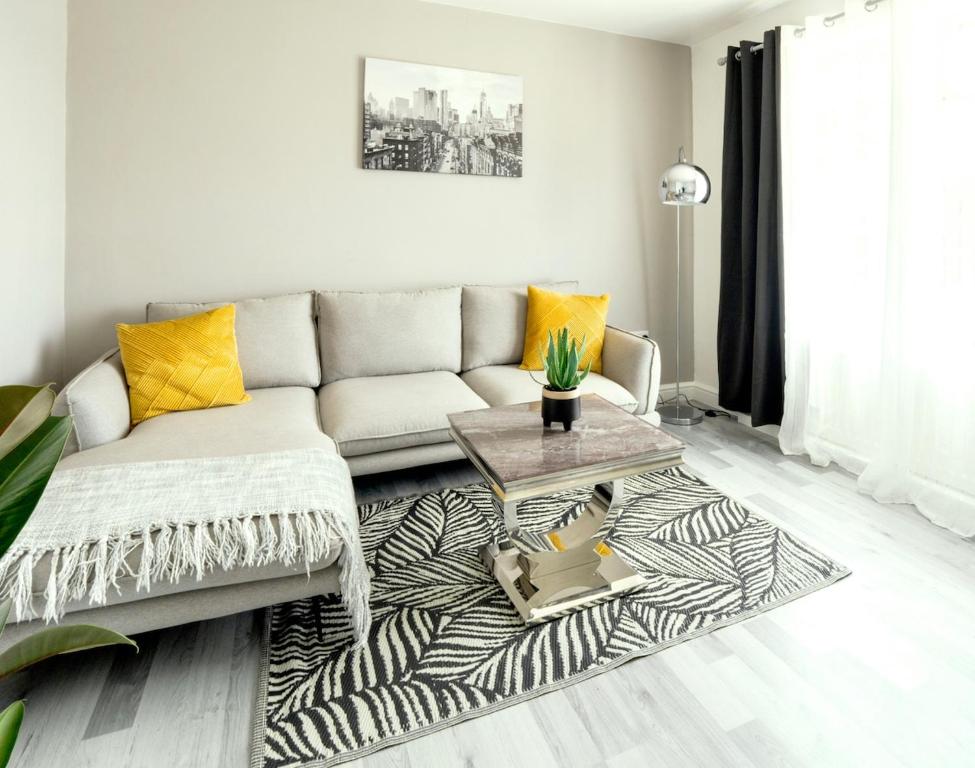 un salon avec un canapé et une table dans l'établissement Stunning Lux 3 Bedroom home Priv Parking in Birmingham, à Kings Norton
