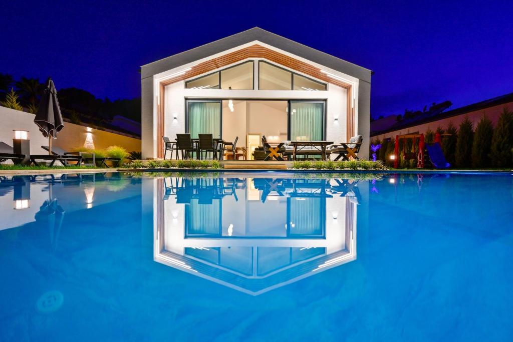 a house with a swimming pool at night at Odella - Luxury Villa for 6 in Seydikemer Zorlar in Fethiye