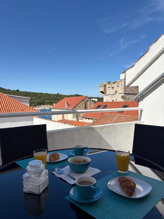 a table with two plates of food on a balcony at Guest House Štorija, Vis Center, 1 min from Ferry in Vis