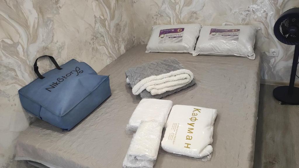 a table with three towels and a bag on it at BURABAY apartments in Borovoye