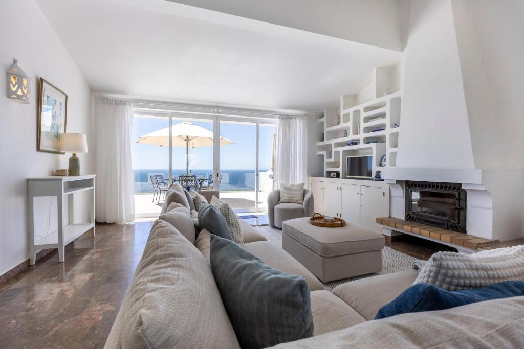 een woonkamer met een bank en uitzicht op de oceaan bij Casa Maresia da Salema in Salema