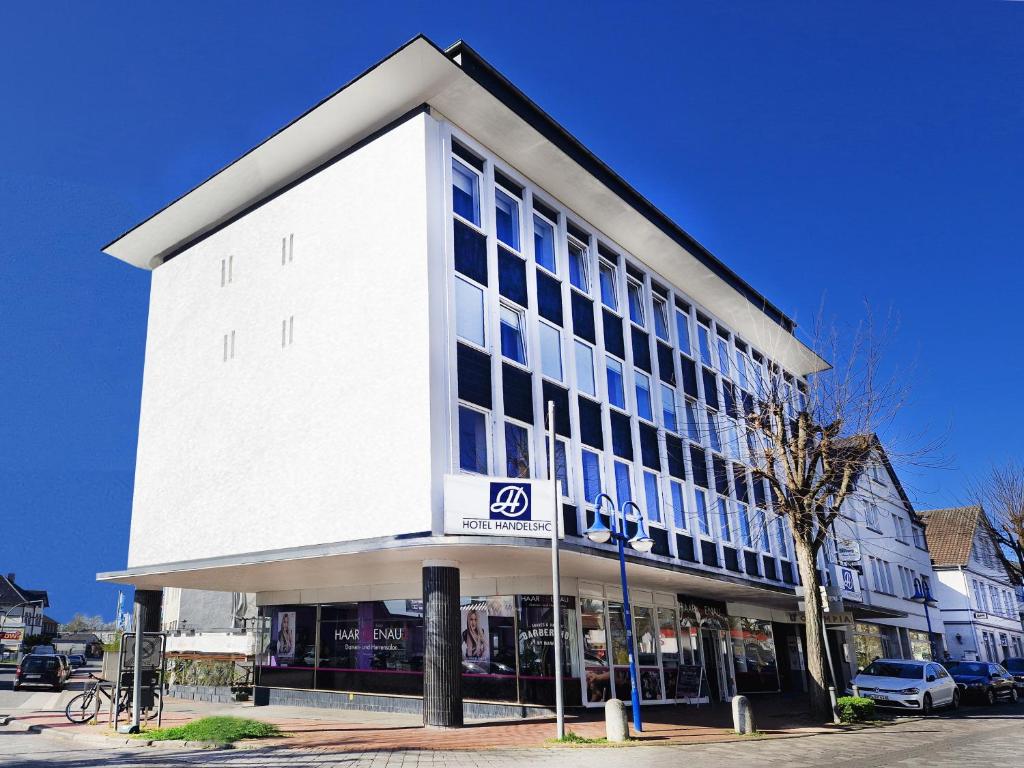 ビュンデにあるHotel Handelshofのたくさんの窓がある大きな白い建物