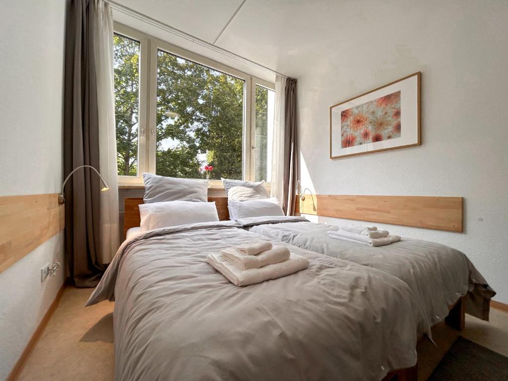 a bedroom with a large bed with two towels on it at Idylle Apartments - Park & Therme in Bad Ems