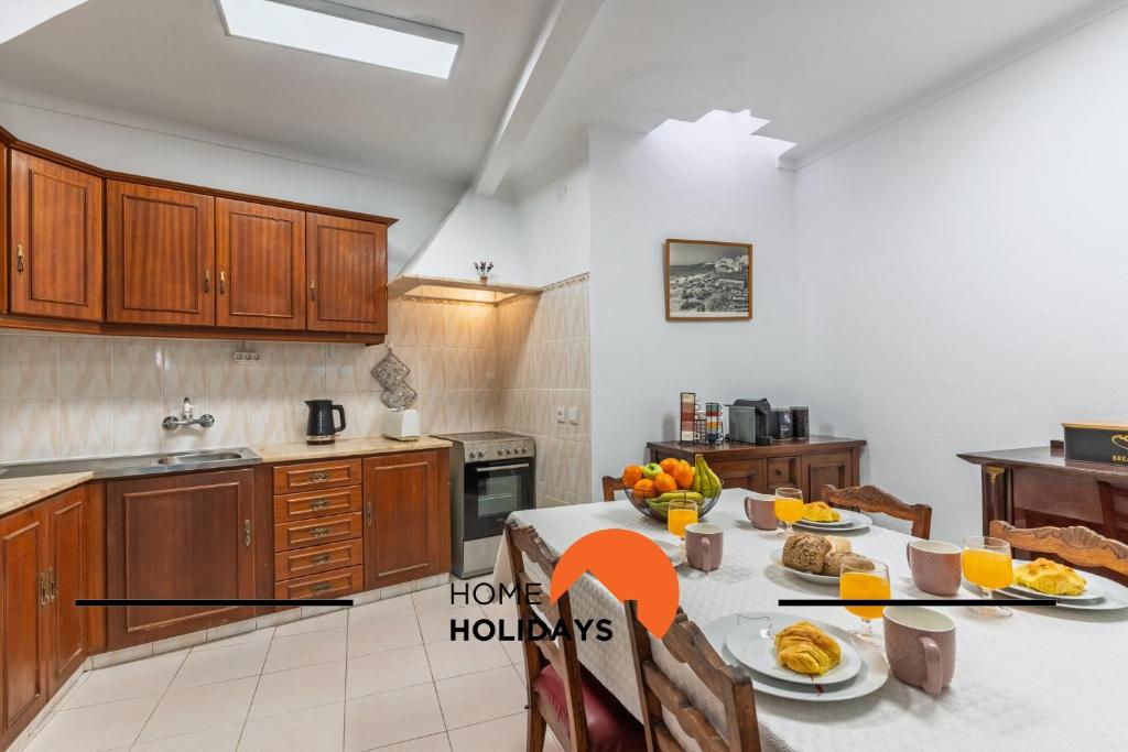 #306 Rua do Saco 11 by Home Holidays في ألبوفيرا: مطبخ مع طاولة عليها طعام