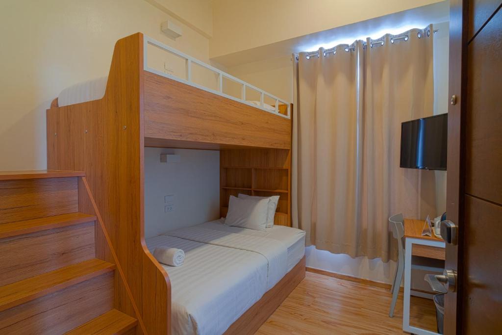 una camera con letto a castello e TV di MySpace Hotel Comembo Taguig a Manila