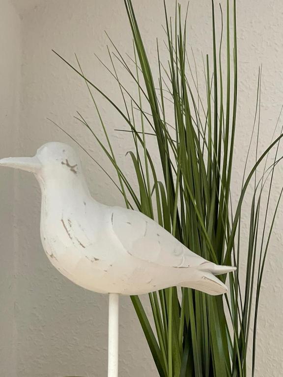 a white bird statue sitting next to a plant at Ferienwohnung Emmi in Nordenham