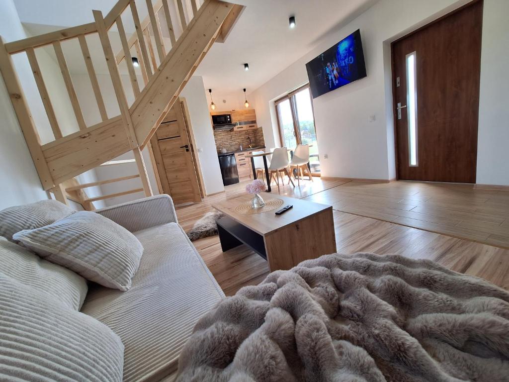 sala de estar con sofá y escalera en Domki Górski Klimat, en Białka Tatrzanska