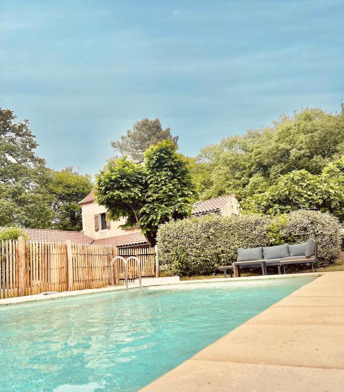 une piscine avec deux bancs et une clôture dans l'établissement Vacation home with pool, à Saint-Martin-le-Redon