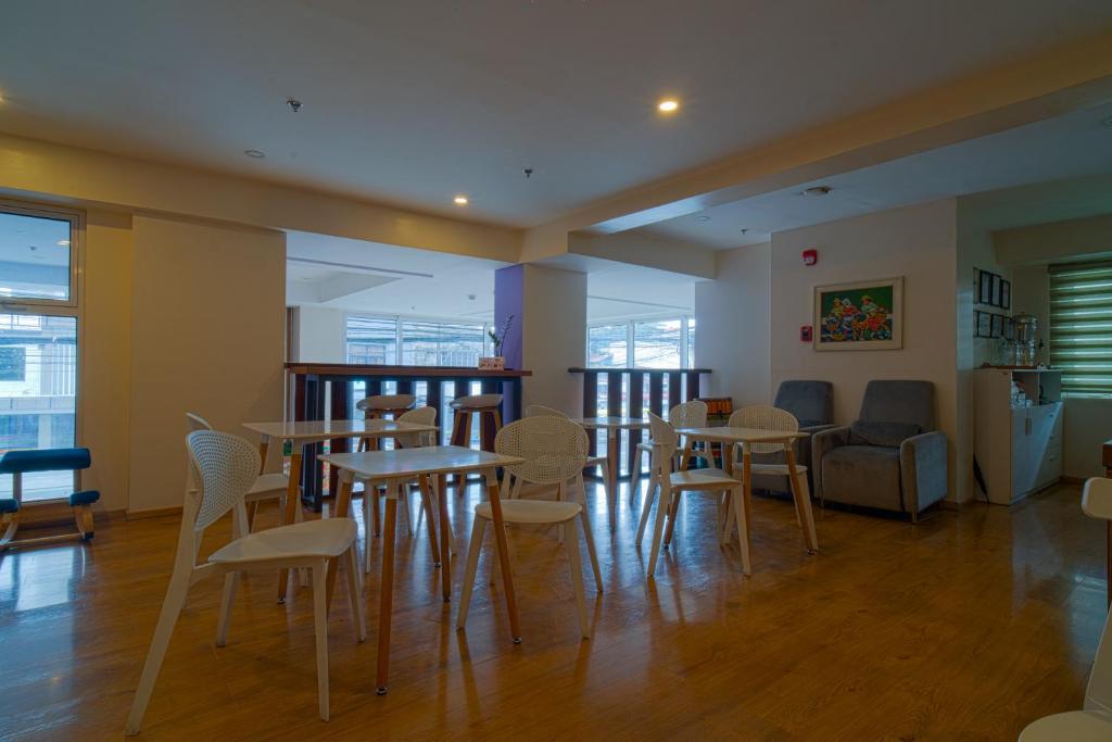 una stanza con tavoli, sedie e un divano di MySpace Hotel Comembo Taguig a Manila