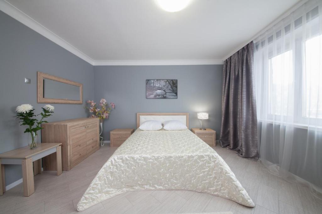 a bedroom with a bed and a large window at Apartment On Dobrovolcheskoy Brigady in Krasnoyarsk