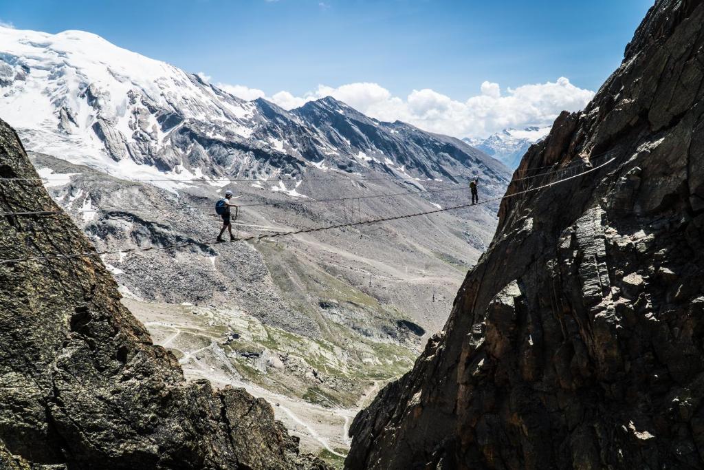 two people on a rope bridge over a mountain at Sunshine in Saas-Grund