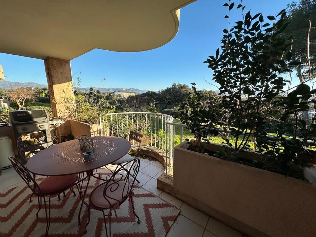 un patio avec une table et des chaises sur un balcon dans l'établissement Apartment Loubet- 2 Bedroom flat with views, à Villeneuve-Loubet