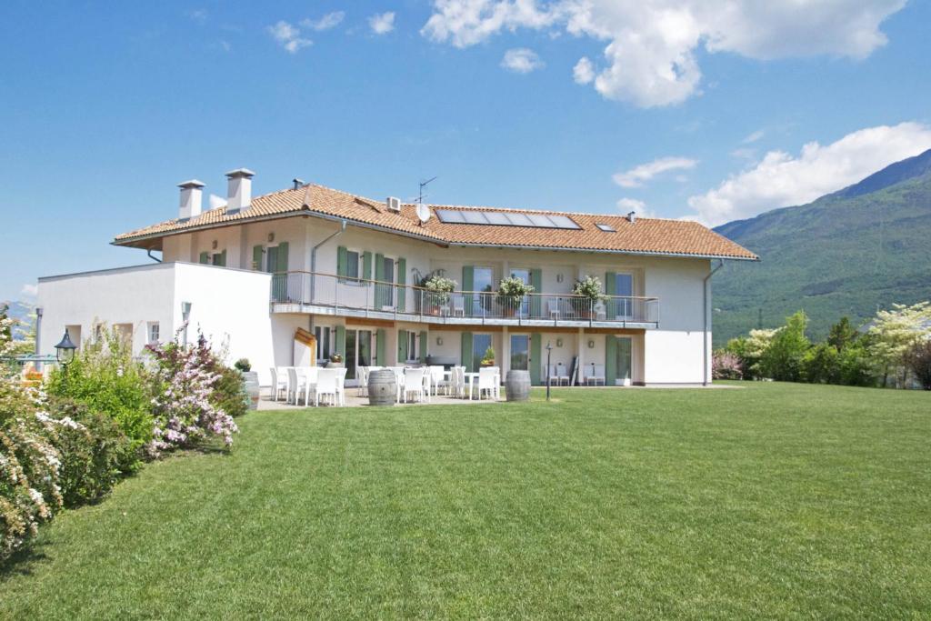 una casa grande con césped delante en Agriturismo Locanda de l'Arguta, en Trento