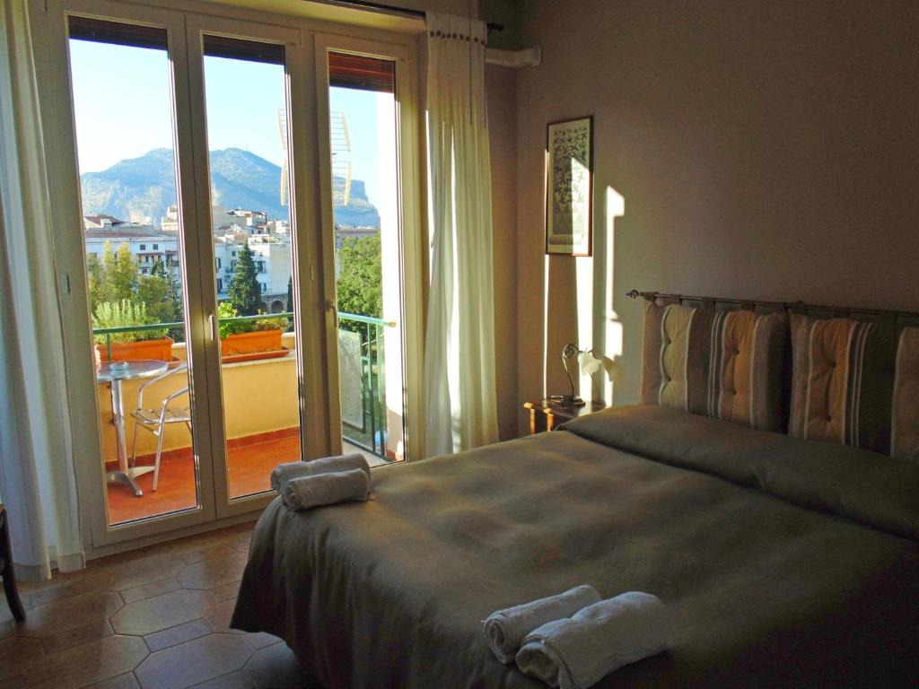 Schlafzimmer mit einem Bett und Blick auf einen Balkon in der Unterkunft Kemonia in Palermo