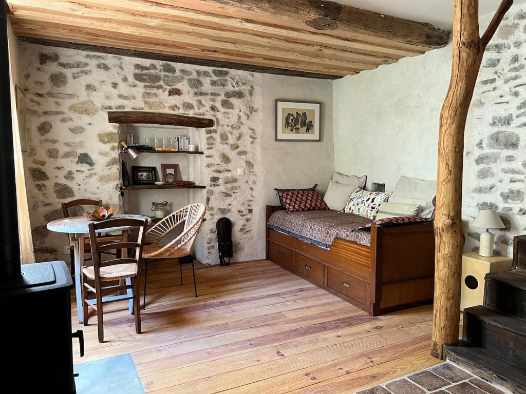 a bedroom with a bed and a table in it at YouMe, petit nid douillet in Aumessas