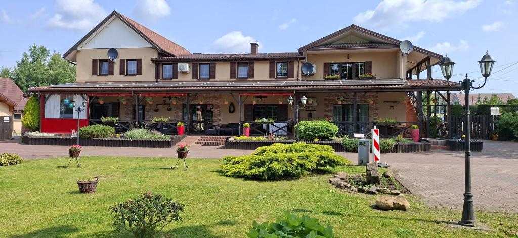 una grande casa con un prato verde davanti di Stajnia pod Dębem a Starachowice