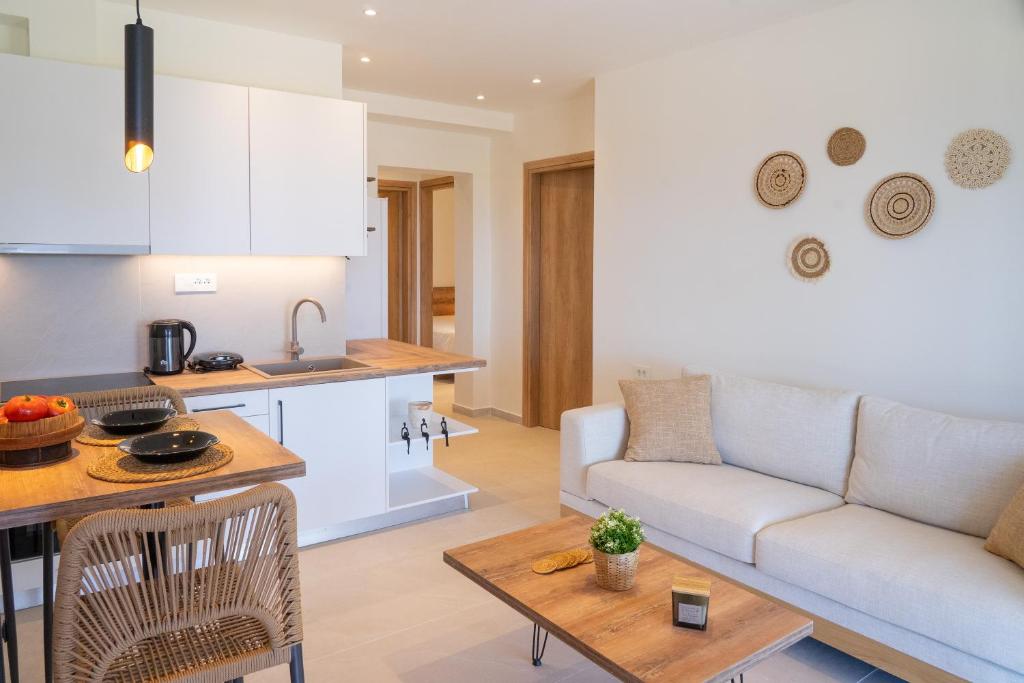 eine Küche und ein Wohnzimmer mit Sofa und Tisch in der Unterkunft Aluna Boutique Suites in Vasilikos