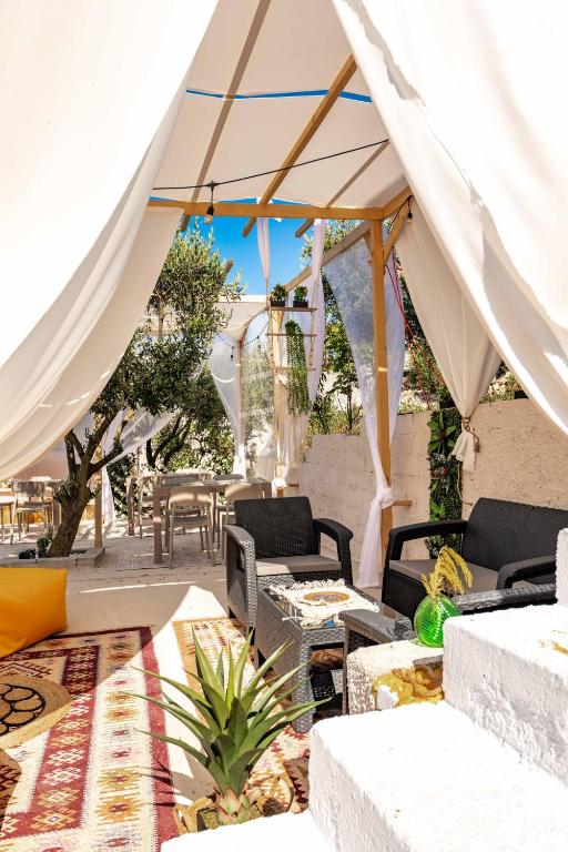 a patio with tables and chairs under a tent at Vila Eden in Ksamil