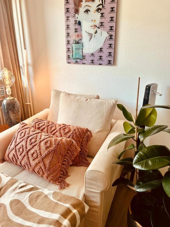 a couch with a blanket and a plant in a room at Business Apartment Karlsruhe Südwest in Karlsruhe