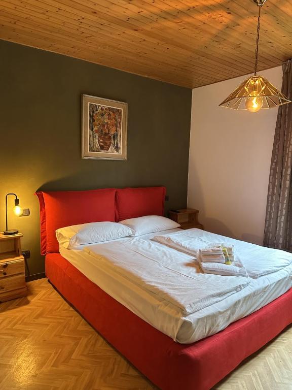 a bed with a red headboard in a bedroom at Ledro Rustik in Ledro
