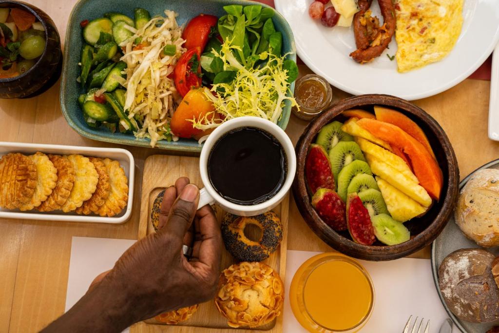 a table full of plates of food with a person taking a picture at ONOMO Hotel Abidjan in Abidjan