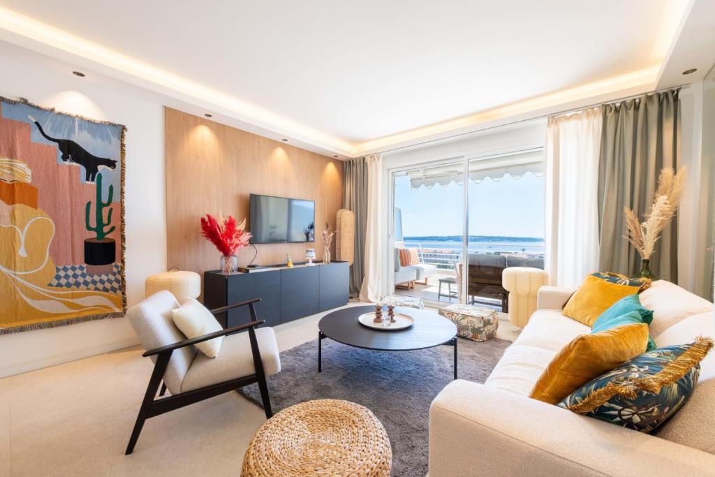 un salon avec un canapé et une table dans l'établissement 2-Br Apartment with Sea View Terrace Cannes, à Cannes