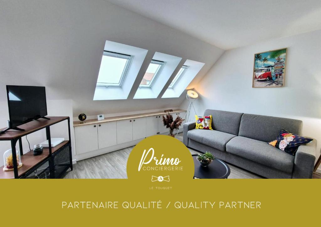 un salon avec un canapé et une télévision dans l'établissement L'Opale, appartement neuf by Primo, à Cucq