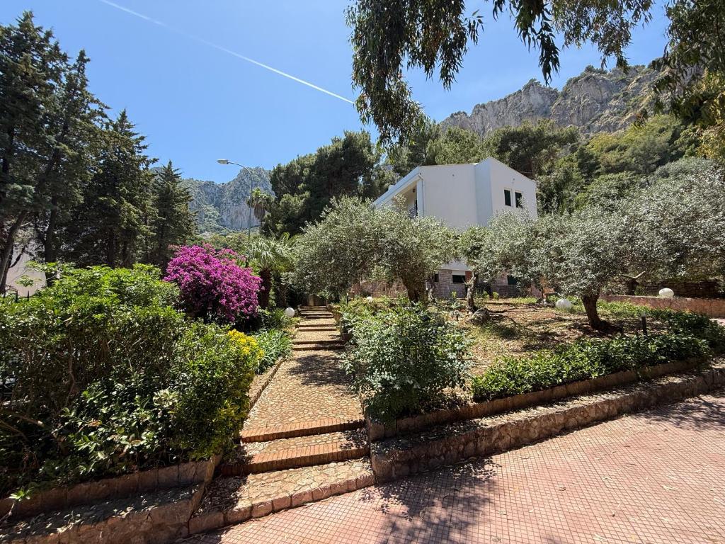 a garden with trees and bushes in front of a building at Villa Rubino Mondello Guest house - By Rentalbeb Italy in Palermo