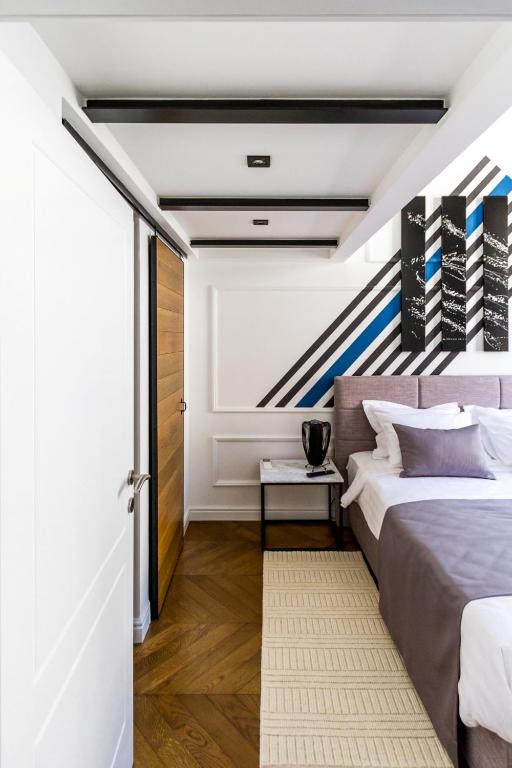 a bedroom with a large bed and a staircase at DeZign Superior Apartments & Rooms in Zadar