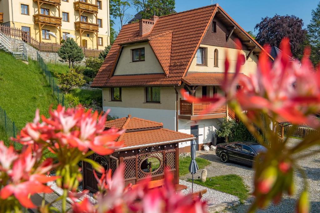 a house with red flowers in front of it at Family House Rosa in Karpacz