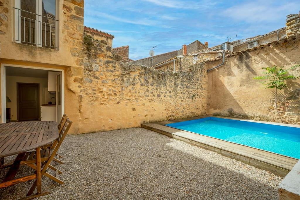 cortile con piscina accanto a un edificio di Magnifique maison climatisée en pierre a Narbonne