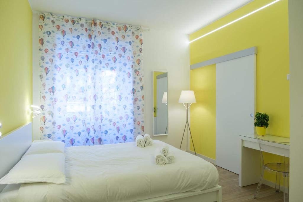 una camera da letto con un letto bianco e una finestra di RainbHome Colourful Roman Suites a Roma