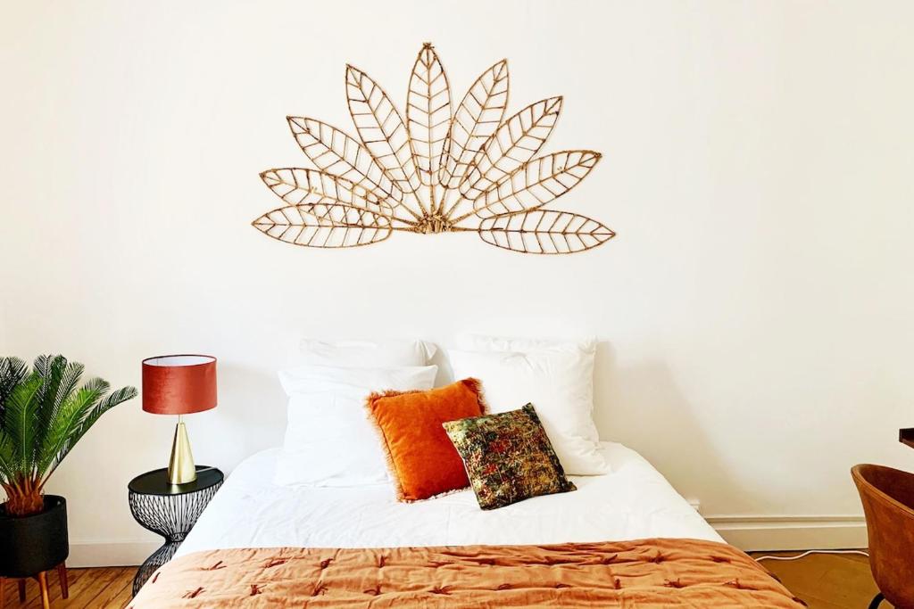 une chambre avec un lit avec des oreillers orange dans l'établissement Bel appartment 2 chambres Hyper Centre Ville, à Quimper