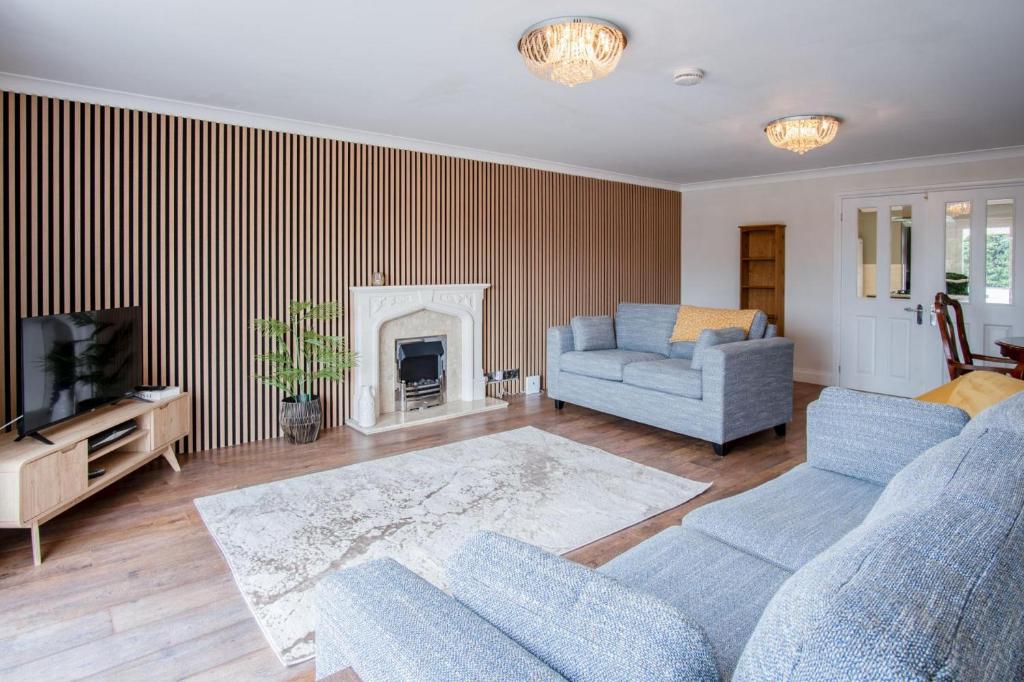 a living room with a couch and a fireplace at Ridgeway Meadow Bungalow - 3 Bedroom - Manorbier in Manorbier
