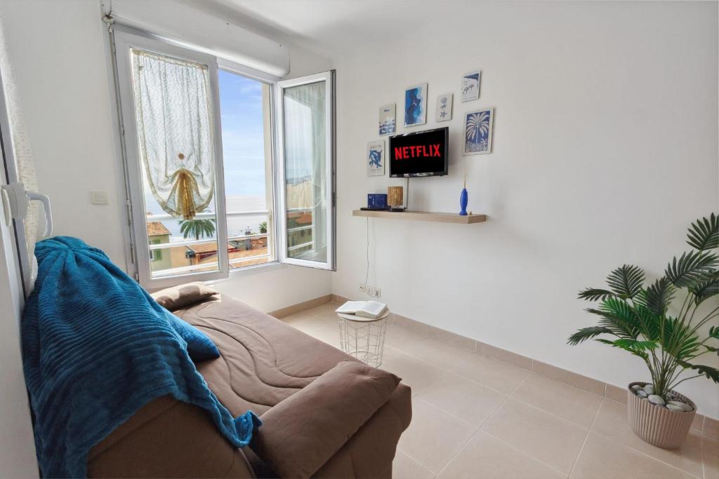 un salon avec un canapé et une horloge au mur dans l'établissement L'Azur - Seaview - AC - Tram - WIFI - Airport, à Nice