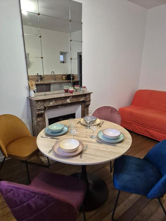 - une salle à manger avec une table, des chaises et un canapé rouge dans l'établissement L'aparté Dijonnaise Hypercentre Dijon Darcy, à Dijon