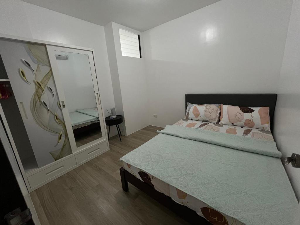 a bedroom with a bed and a large mirror at Loven Transient House in Dauis