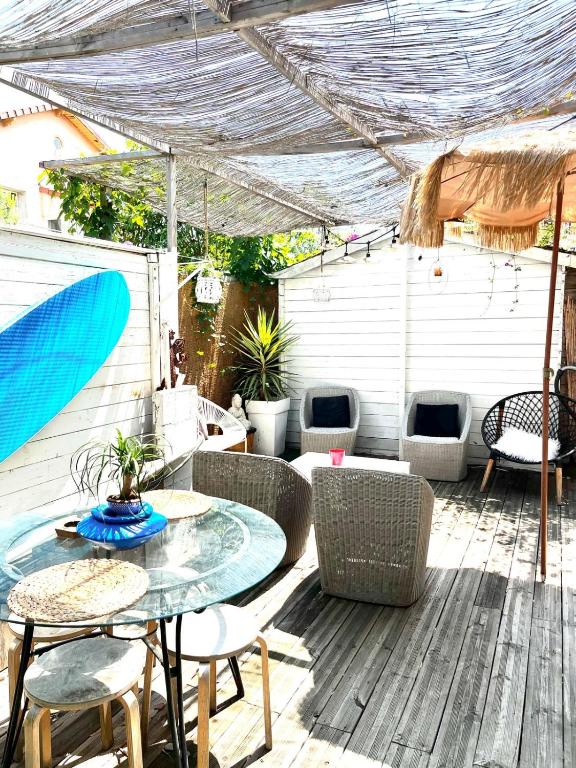 a patio with a table and chairs on a deck at Le Bohème 3 pièces jardin in Saint-Laurent-du-Var