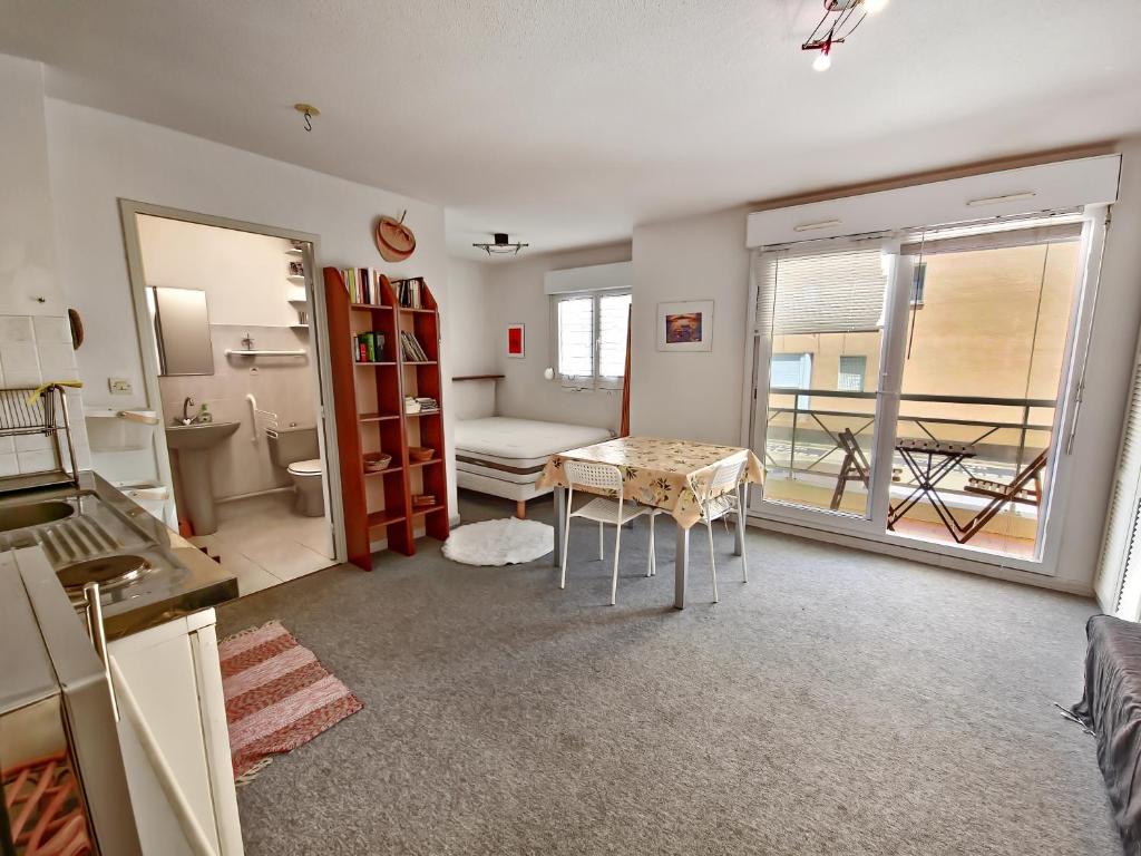 un salon avec une table et une salle de bains. dans l'établissement Studio Coralines Plage 500 m, au Lavandou